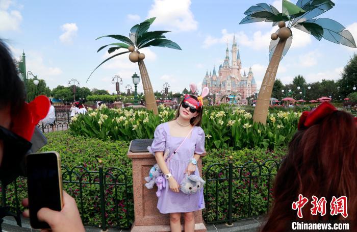 游客在迪士尼乐园拍照留念。　汤彦俊 摄