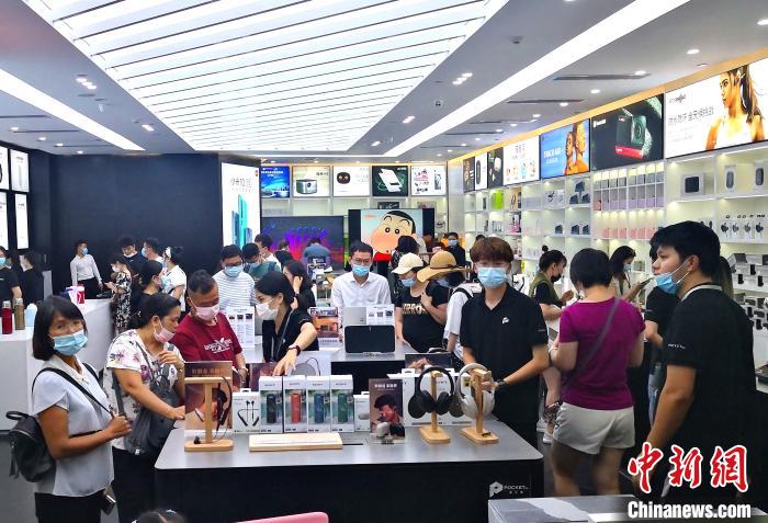 图为8月26日游客在三亚国际免税城内选购电子产品。　尹海明 摄