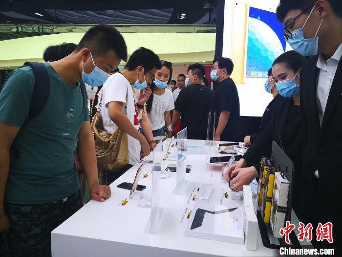 图为8月26日游客在三亚国际免税城内选购电子产品。　尹海明 摄
