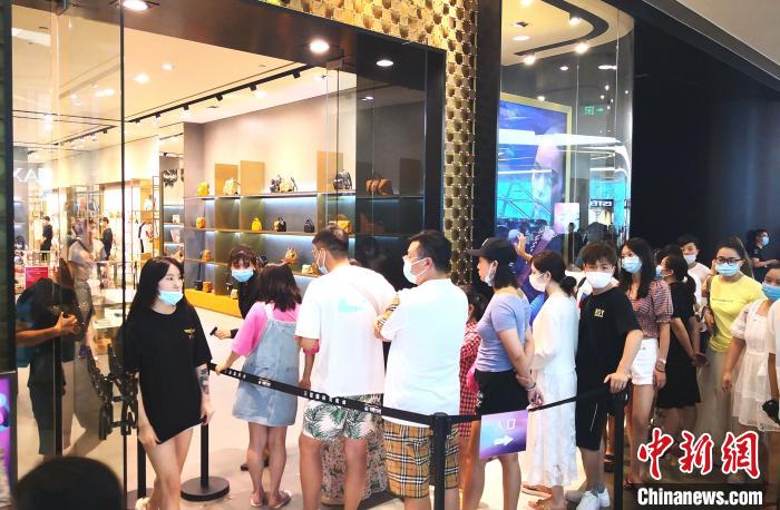 图为8月26日游客在三亚国际免税城内排队进店购物。　尹海明 摄