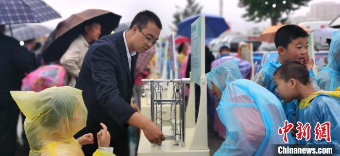 图为学生在雨中体验趣味科技。　魏建军 摄