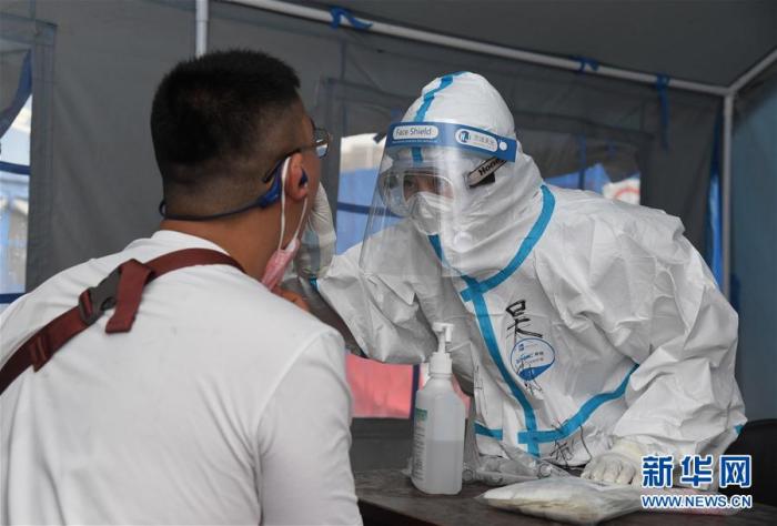 6月18日，在海淀区区级核酸检测采样点，医护人员为市民进行核酸检测采样。新华社记者 任超 摄