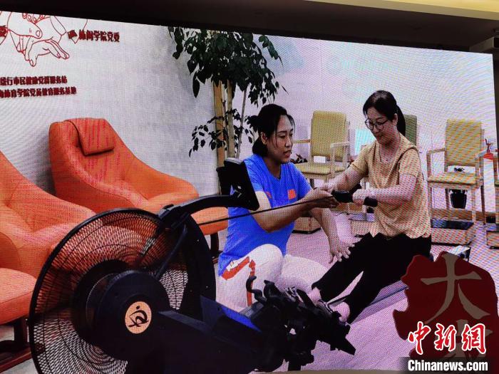 张杨杨在现场互动中指导民众正确使用划船机锻炼。　陈静 摄