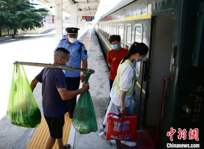 9月3日，一名菜农正在准备登乘6025/6次九江—麻城“公益慢火车”。　胡国林 摄